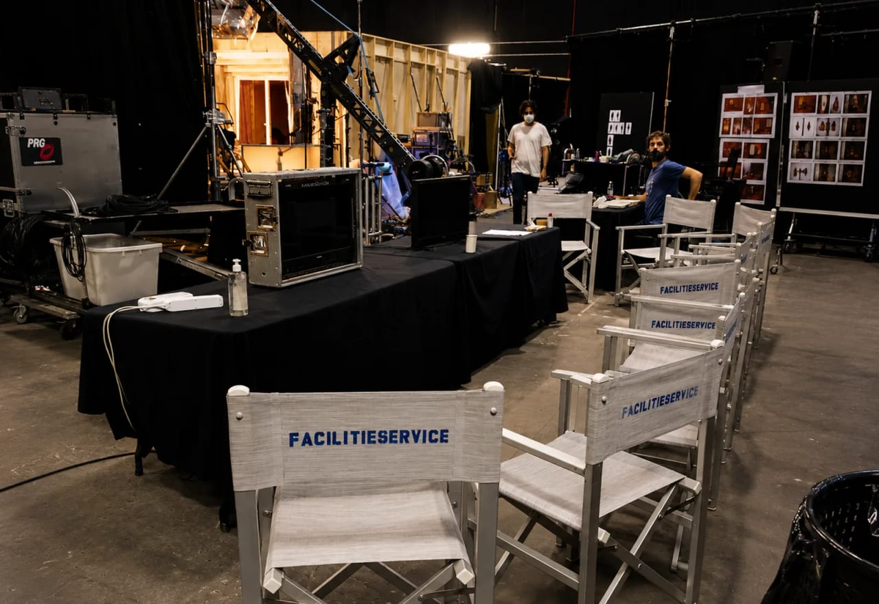 Sedie regia e postazione produzione in un backstage Facilitieservice